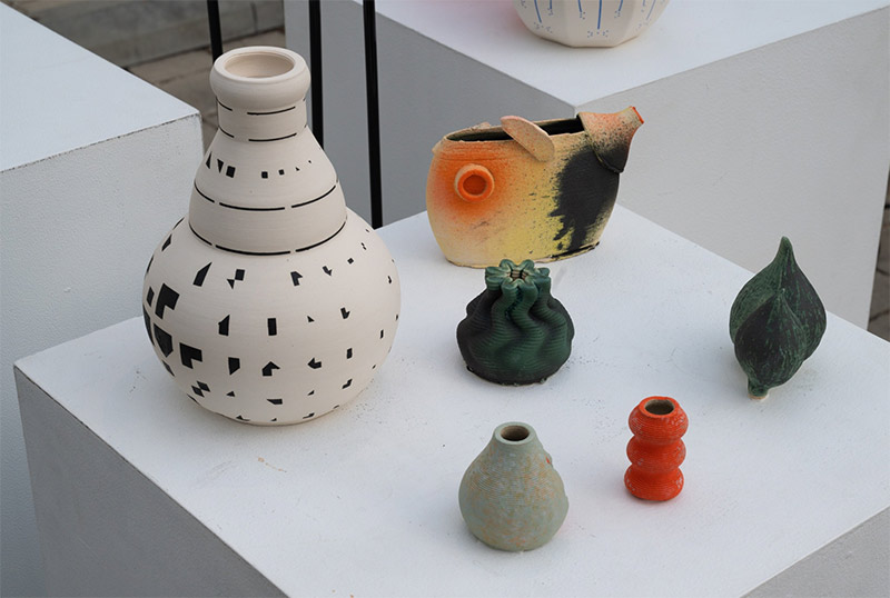 Several small, colorful ceramic vases on a pedestal.